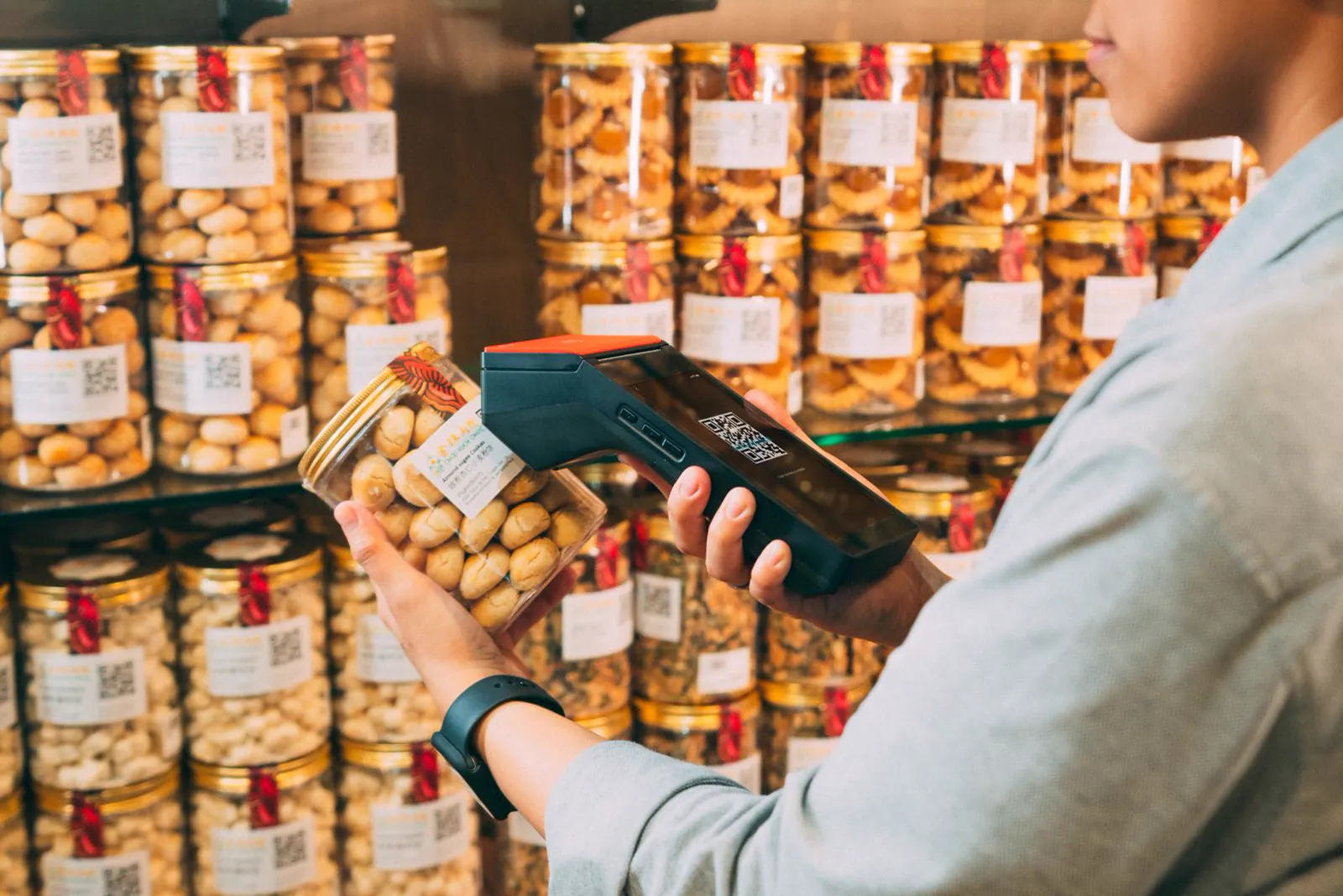 Store employee scanning a labelled jar with a handheld inventory device